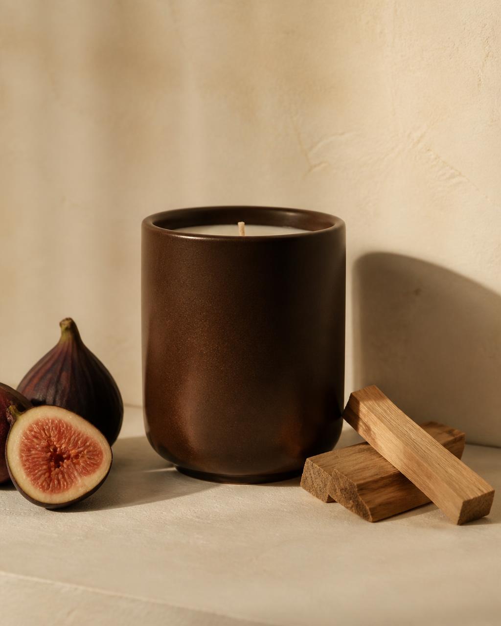 NOCTÉ No. 02 Fig & Sandalwood candle in a deep brown ceramic vessel with fresh figs and sandalwood